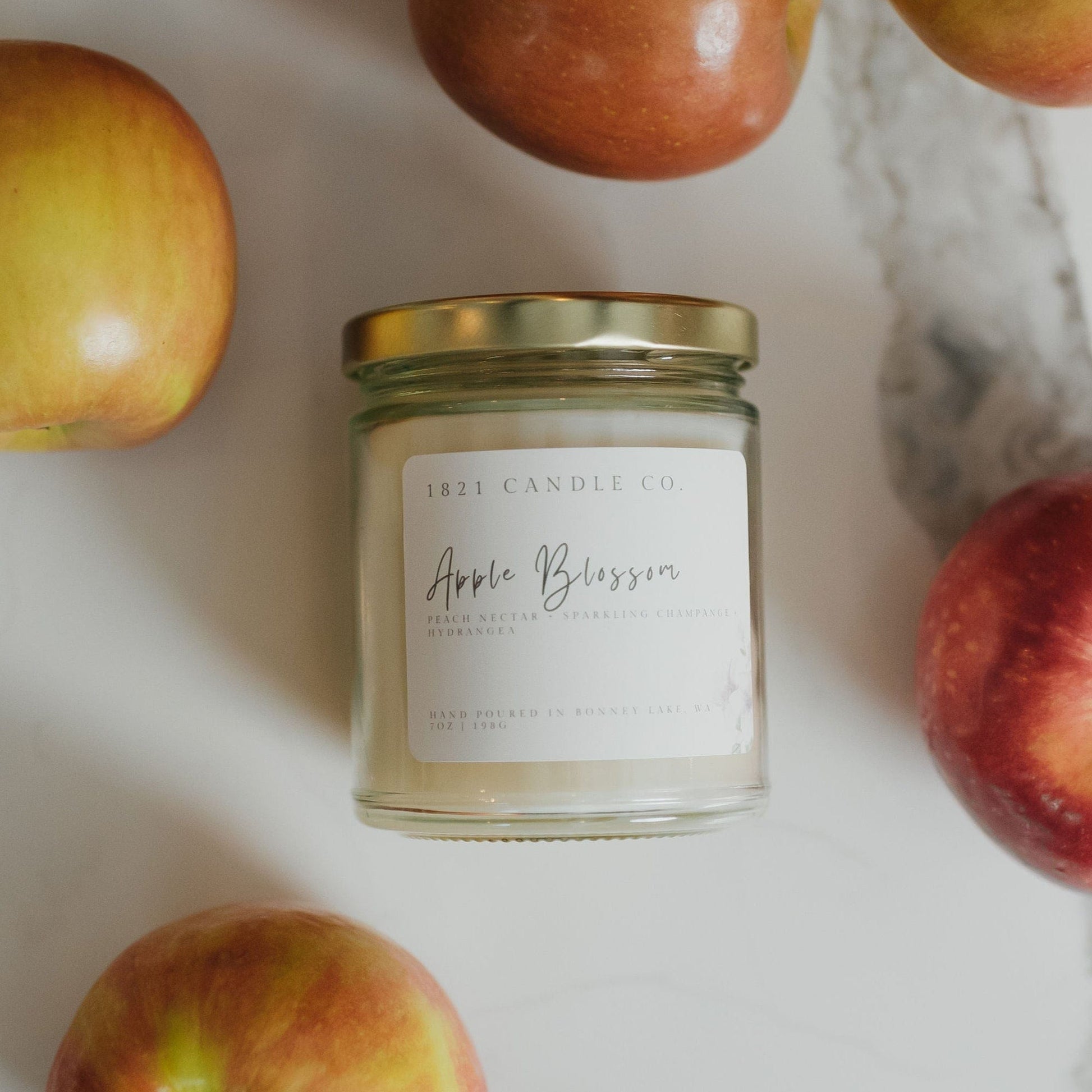 Apple Blossom candle with fresh red apples - a non-toxic handmade candle perfect for kitchen and farmhouse decor.