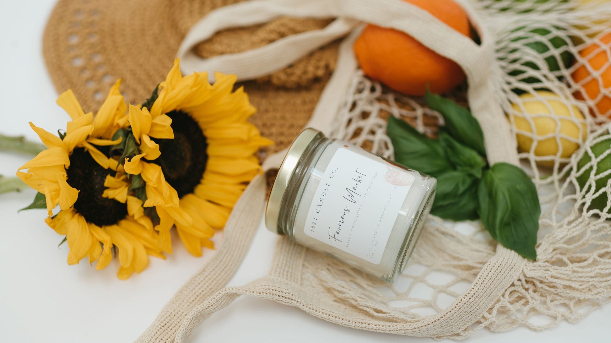 Farmers Market summer kitchen candle by 1821 Candle styled in a rustic summer tote with sunflowers and fresh produce.