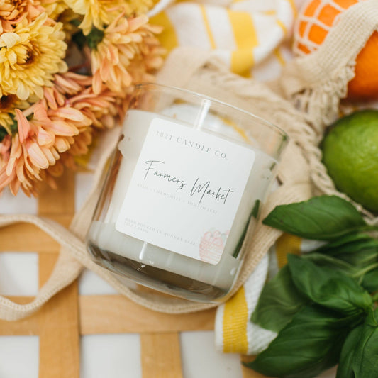 Farmers Market Handmade Candle by 1821 Candle Co handmade in Bonney Lake, Wa featuring fresh basil, chamomile and tomato leaf. Displayed with fresh flowers, citrus and basil on woven tray.