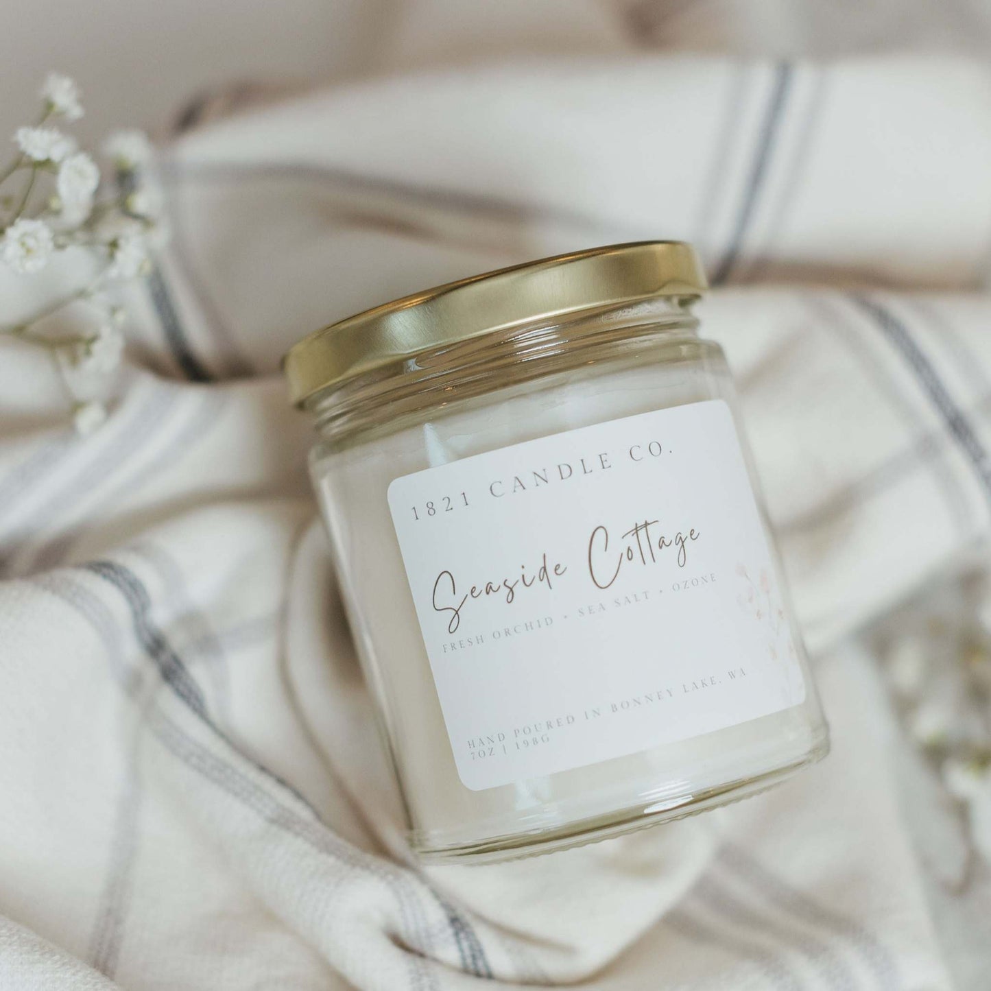 hand poured soy blend candle in a minimalist glass jar, placed on a textured linen background. A clean and timeless home fragrance perfect for fresh, spring moments.