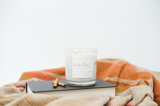 Vanilla Chai soy blend fall candle on a book with a warm blanket in the background