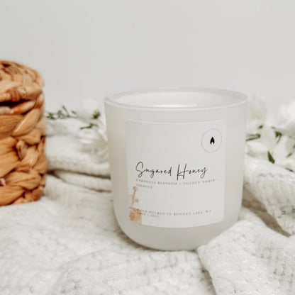 Sugared Honey Candle with white florals and a wicker basket in the background