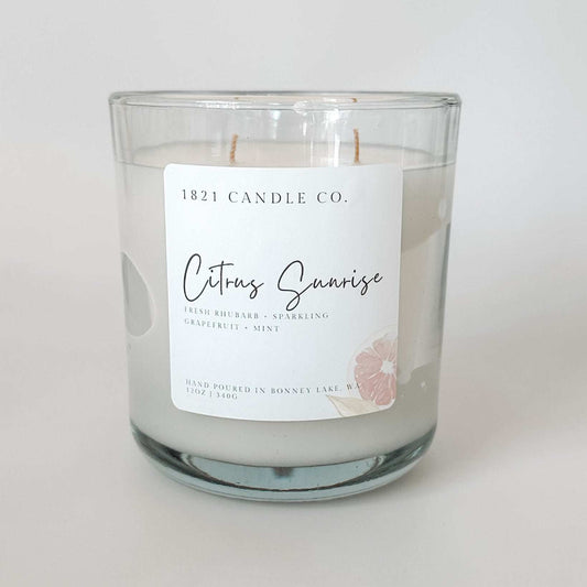A Citrus Sunrise Double Wicked 12oz Candle from 1821 Candle Co, featuring notes of grapefruit, rhubarb, mint and vanilla.