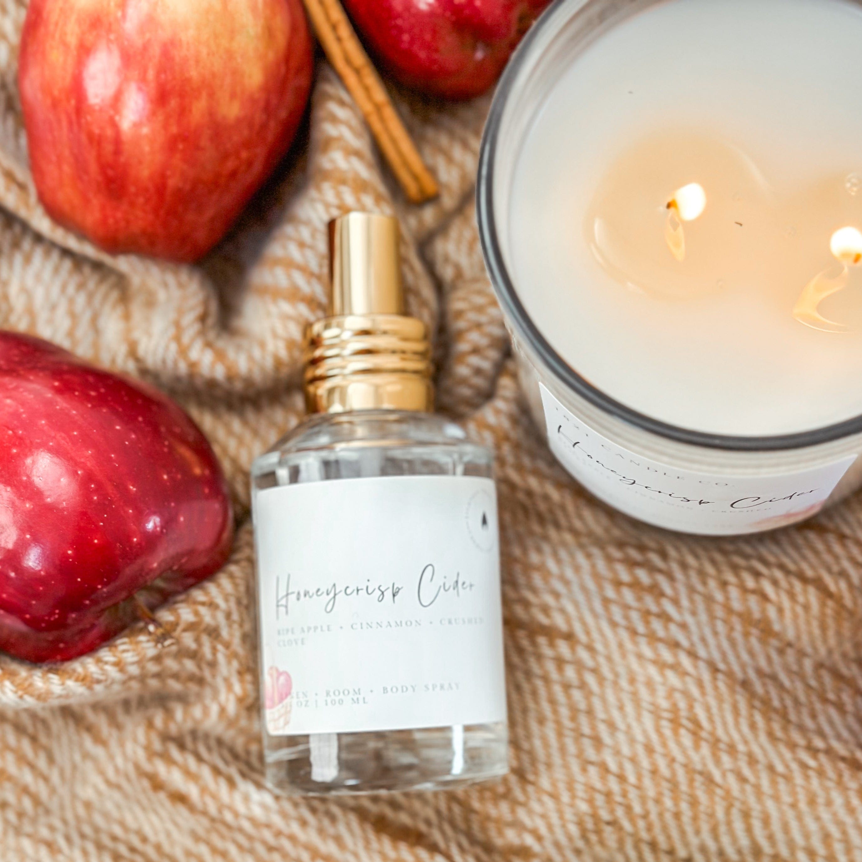 Honeycrisp Cider Candle, linen spray, and apples on a textured blanket made by 1821 Candle Co in Bonney Lake WA