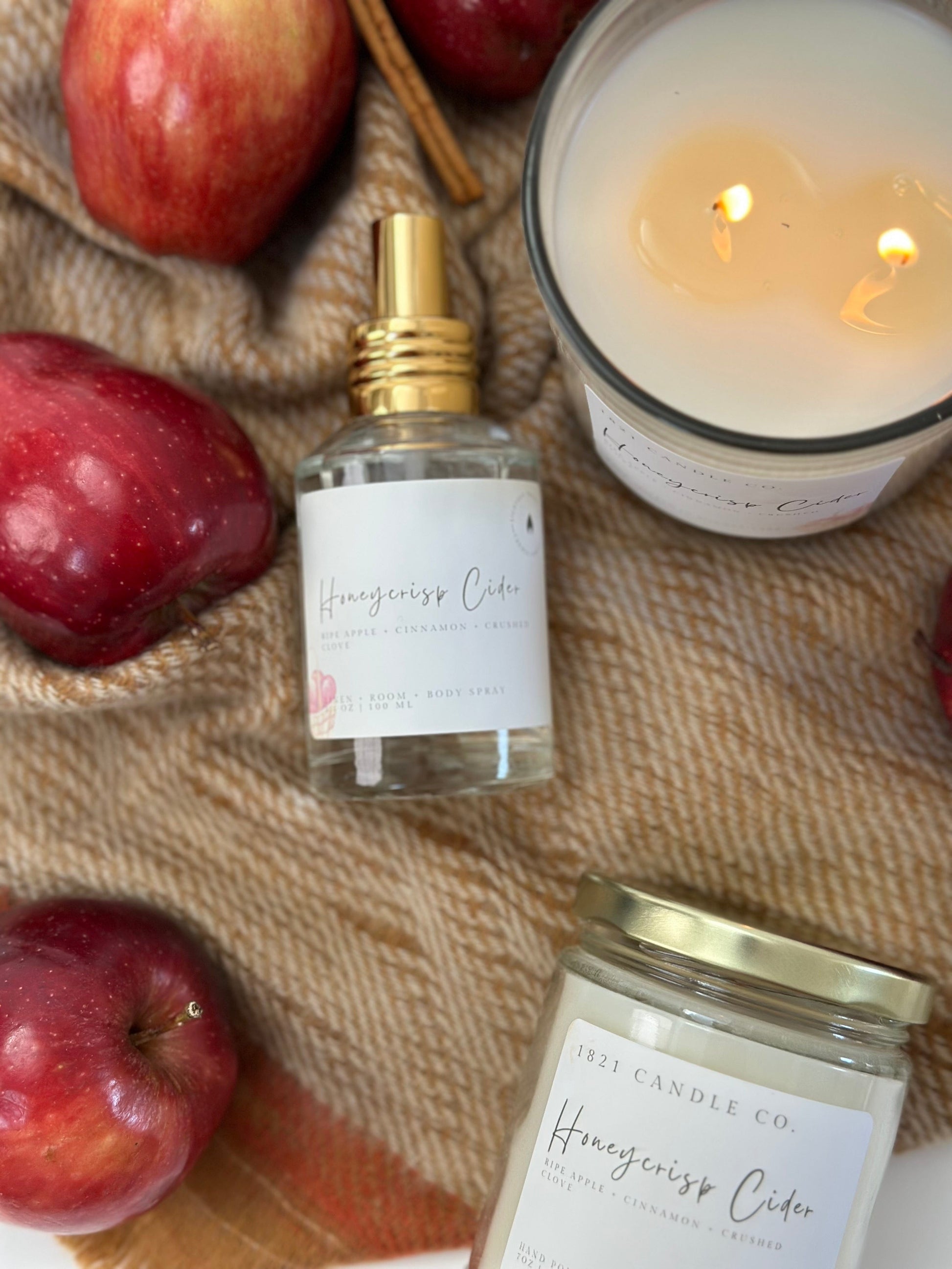 Honeycrisp Cider  air freshener & soy blend candles with apples and a candle on a textured surface