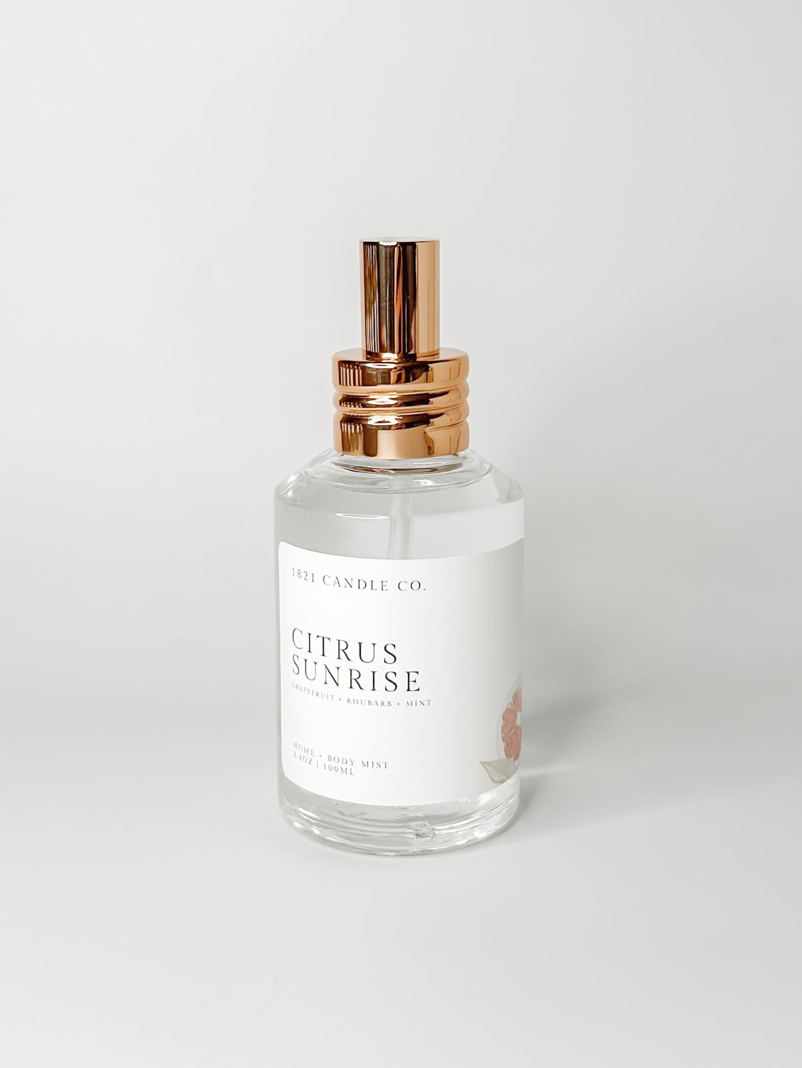 Citrus Sunrise non toxic, clean home and body spray in a clear spray bottle with a gold lid on a white background. Made in small batches in Washington