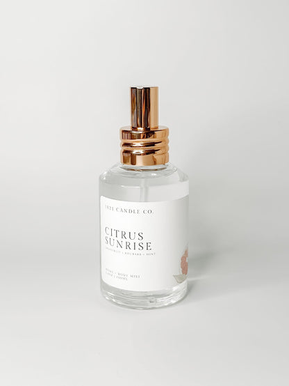 Citrus Sunrise non toxic, clean home and body spray in a clear spray bottle with a gold lid on a white background. Made in small batches in Washington