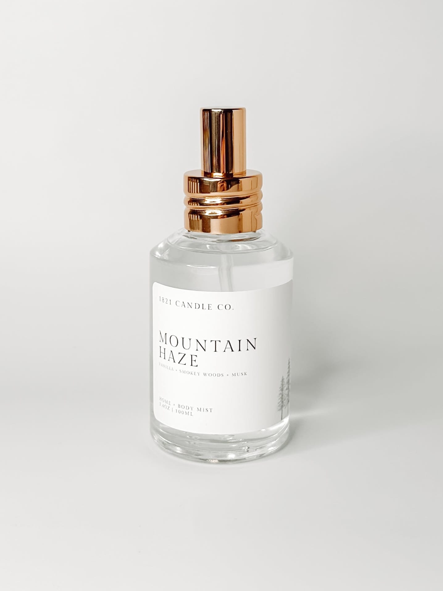 Mountain Haze non toxic, clean ingredient room spray and body mist with notes of vanilla, smokey woods and lavender in a clear glass bottle with a gold spray top by 1821 candle co. Made in small batches in washington.