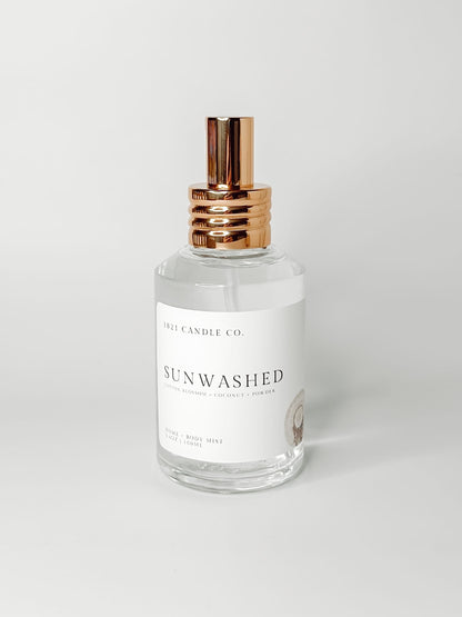 Sunwashed clean, phthalate free home and body mist made by 1821 candle go in washington in a clear glass bottle with a gold spray cap on a white background. Notes of coconut, powder and cotton blossom.